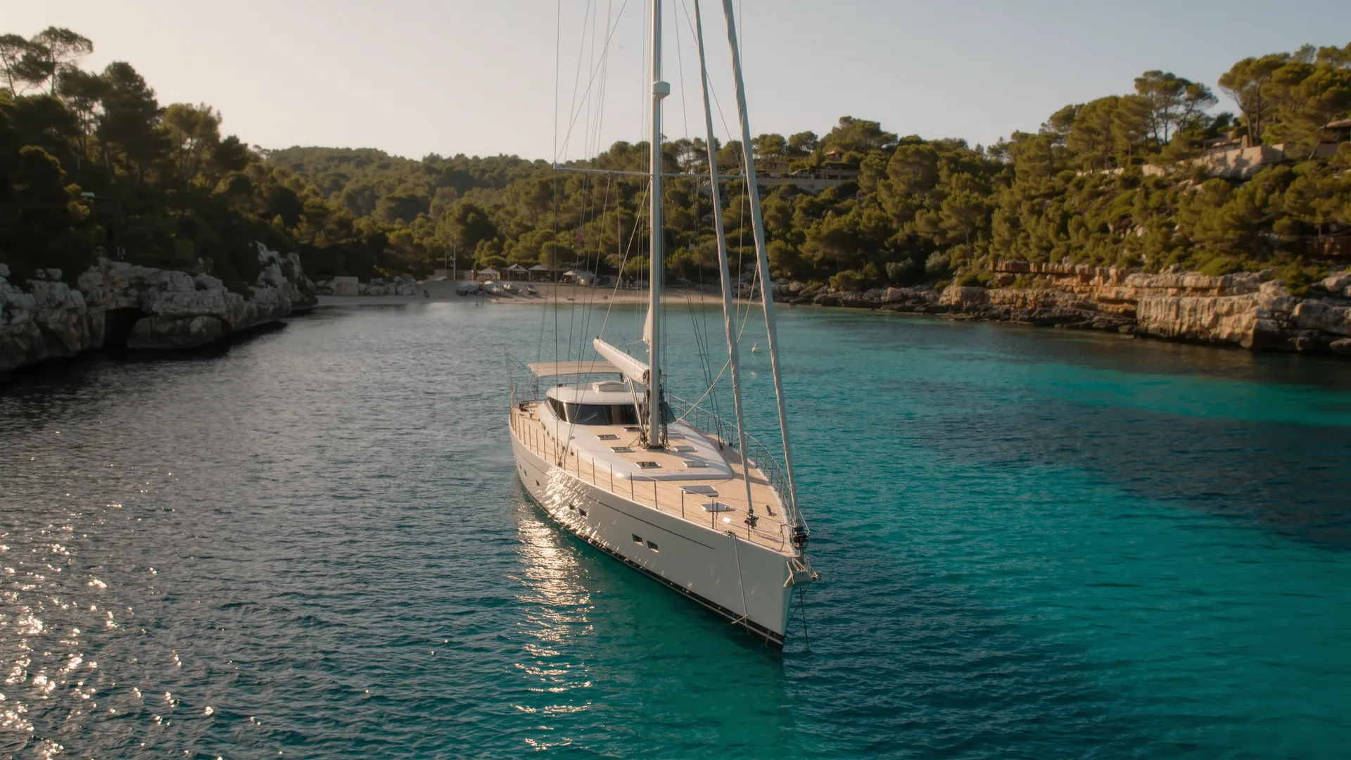 Sailing yacht anchored in a turquoise Mallorcan bay at dusk