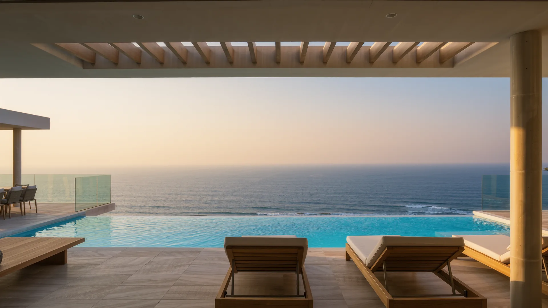 Modern villa terrace with an infinity pool above the Mediterranean at dusk