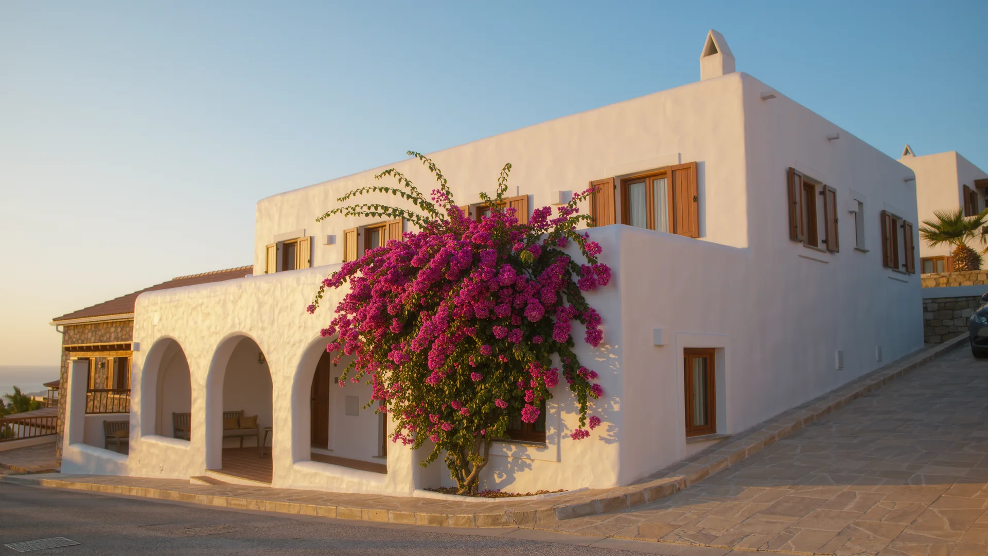 Andalusian white house with bougainvillea under a clear sky