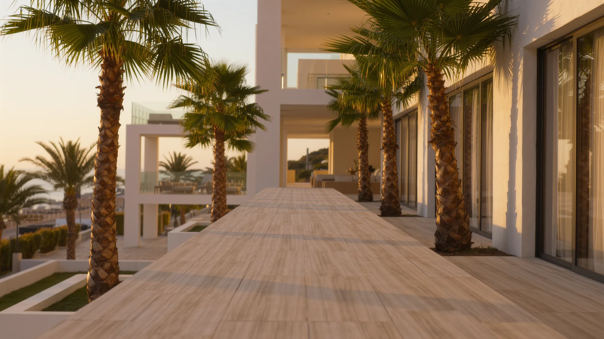 Apartment building courtyard with palms and a clean tiled walkway in morning light