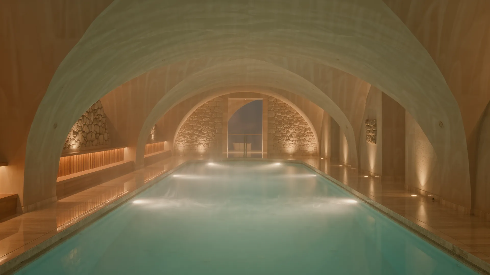 Hotel spa pool lit from below in a stone vaulted room