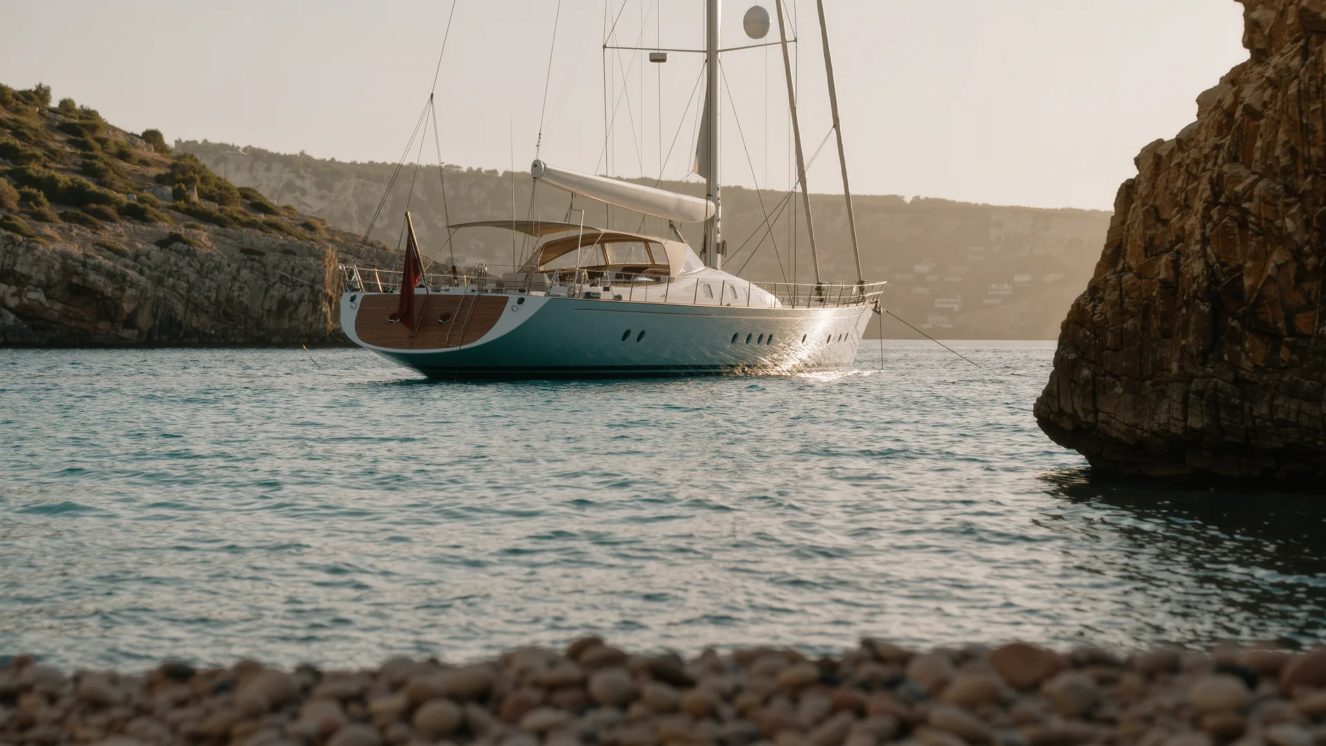 Sailing yacht anchored in a turquoise Mallorcan bay at dusk