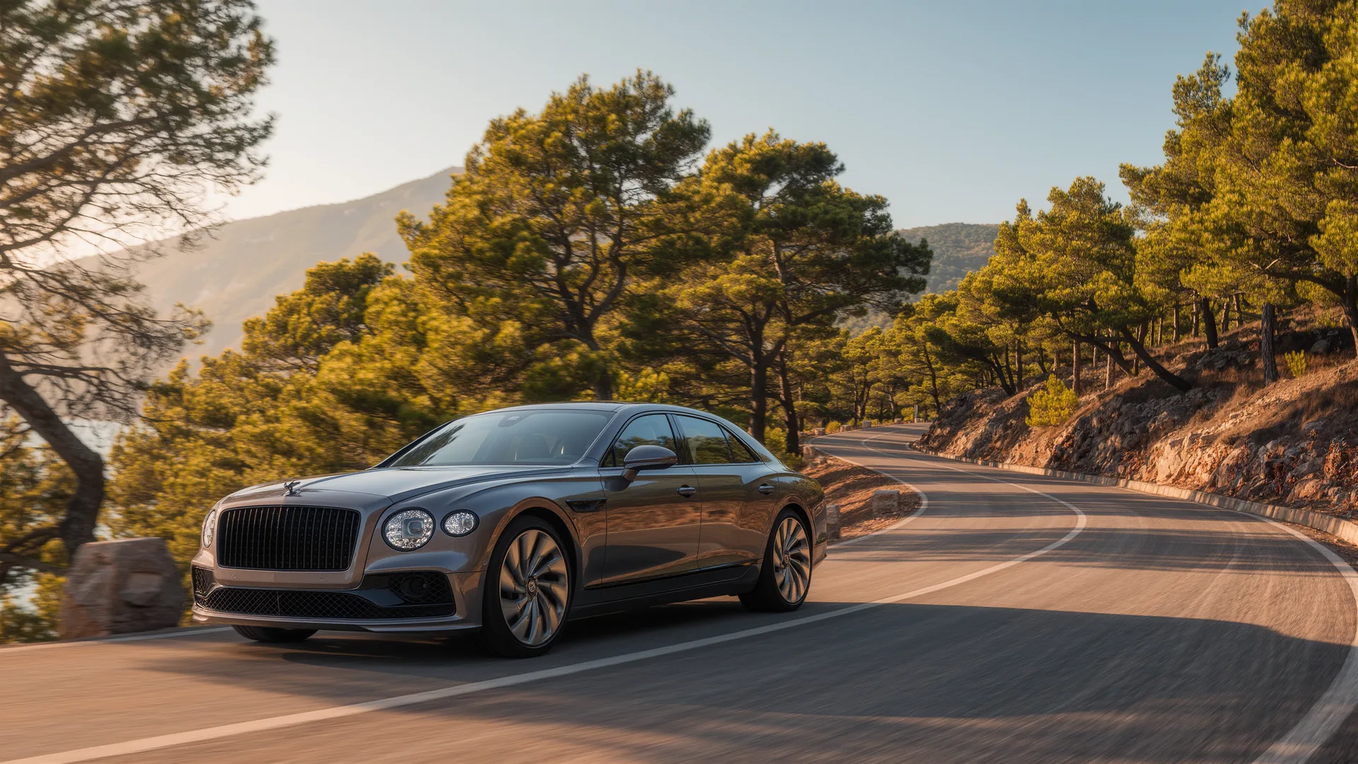Car on a winding mountain road through pine trees