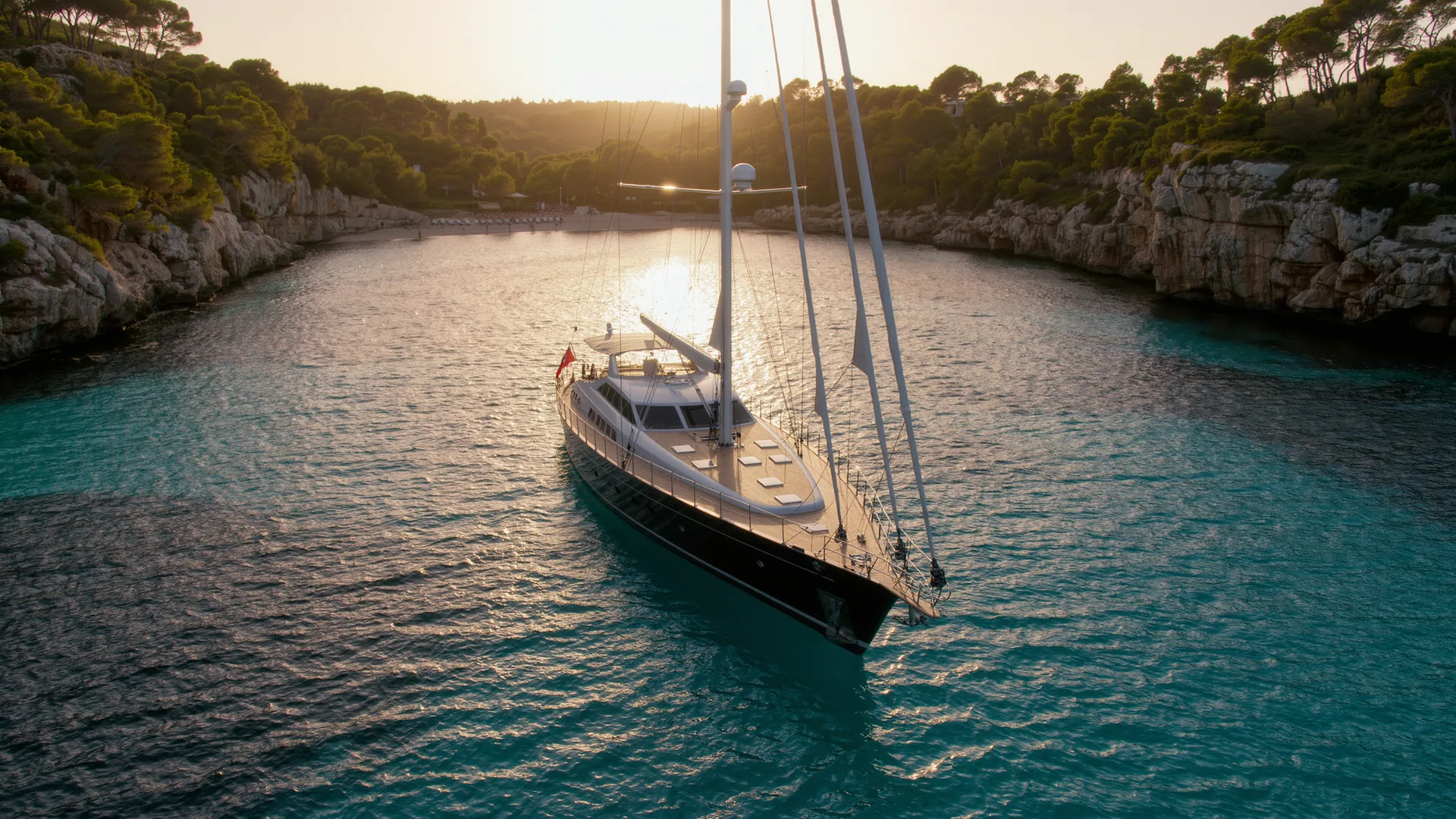 Sailing yacht anchored in a turquoise Mallorcan bay at dusk